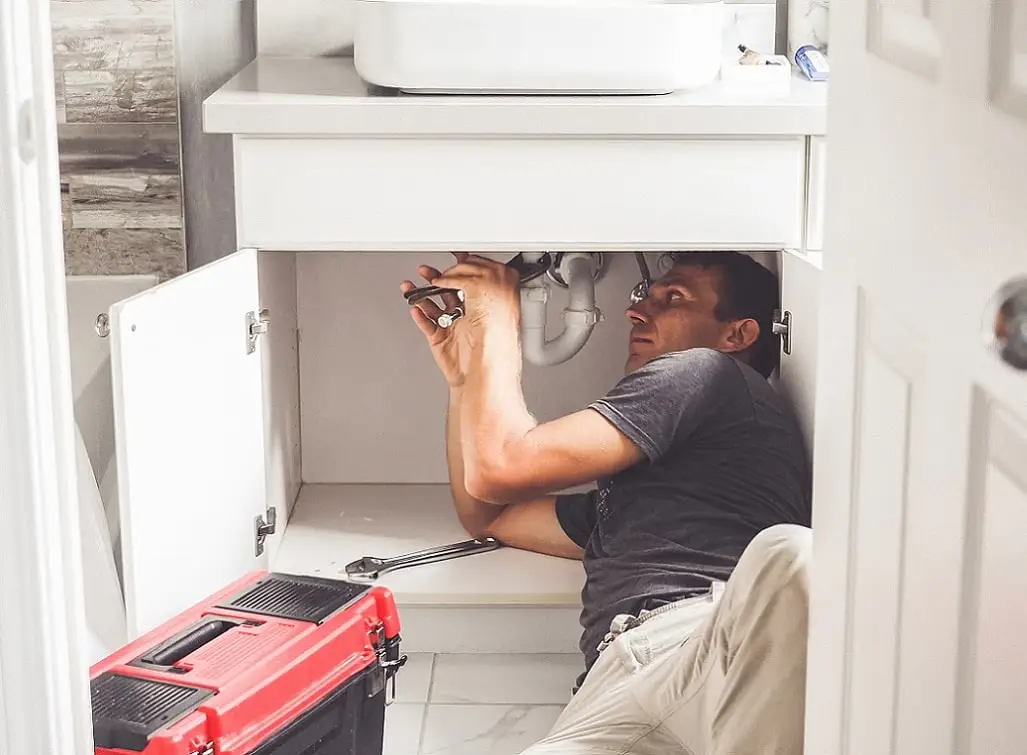 EZO plumber working on an emergency leak in a UK home